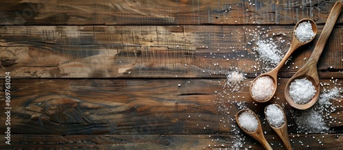 Sea salt spoons on a rustic wooden table with ample copy space image. photo