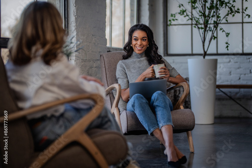 Afro-american woman sitting in a cafe and talking to her friend