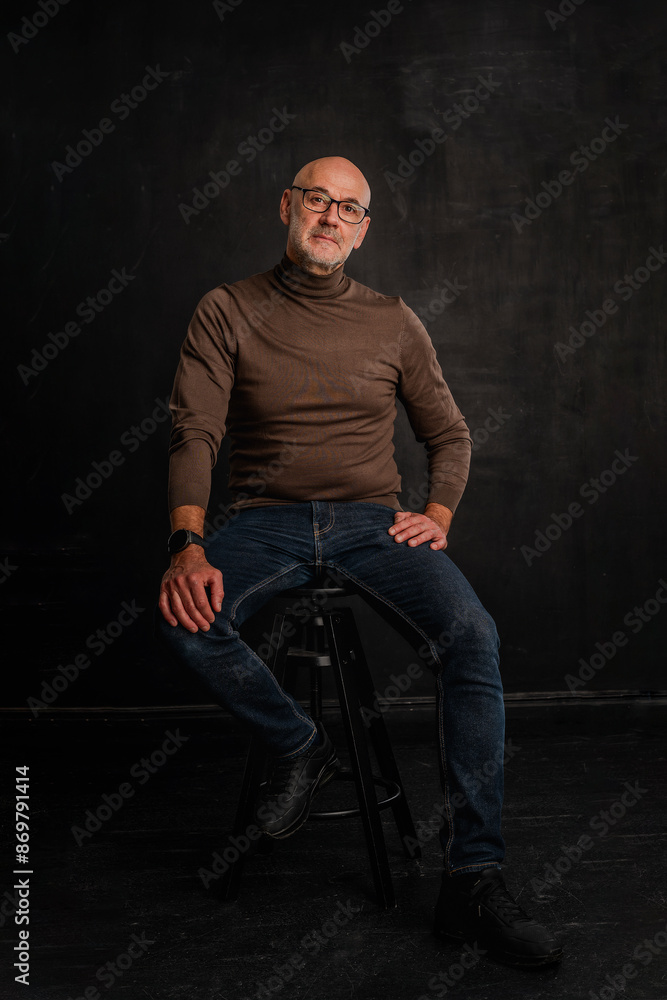 Full length of a mid aged man sitting against isolated background Full length of a mid aged man sitting against isolated background