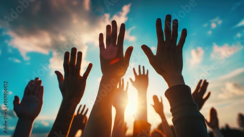 Hands raised in unity at sunset. Crowd with hands raised in the air at a sunset, symbolizing unity, hope, and celebration.