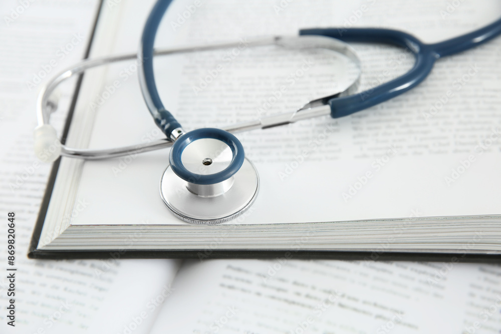 One new medical stethoscope and books on table, closeup One new medical stethoscope and books on table, closeup