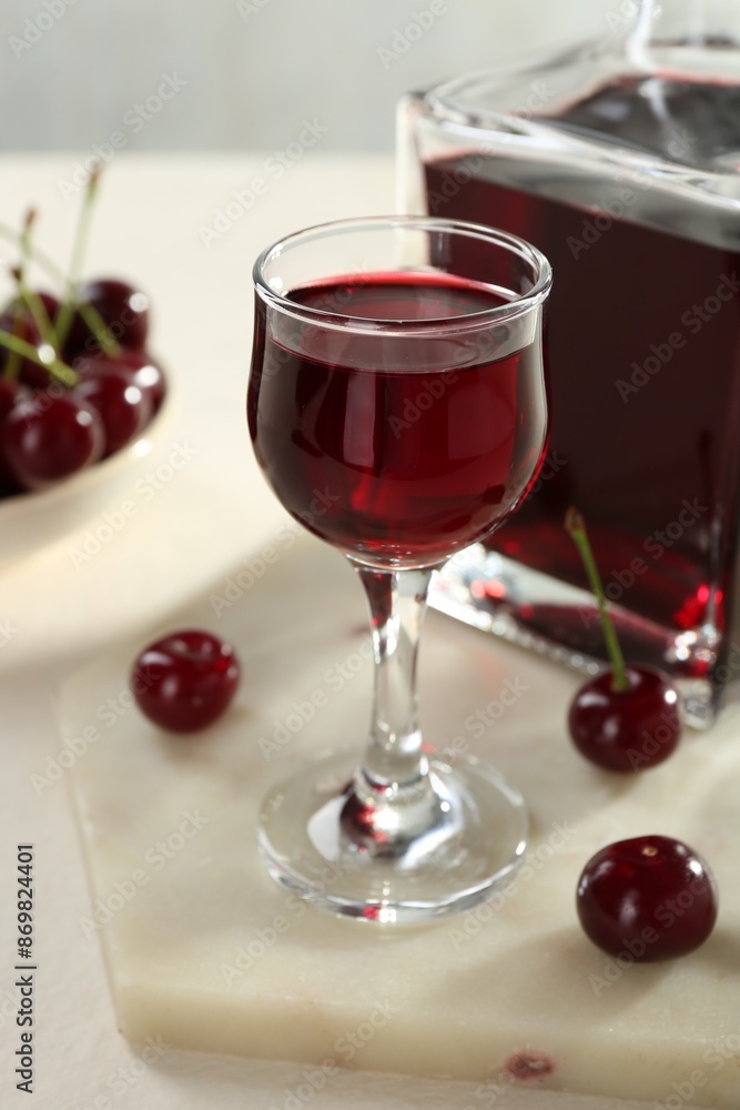 Delicious cherry liqueur and berries on white table, closeup Delicious cherry liqueur and berries on white table, closeup