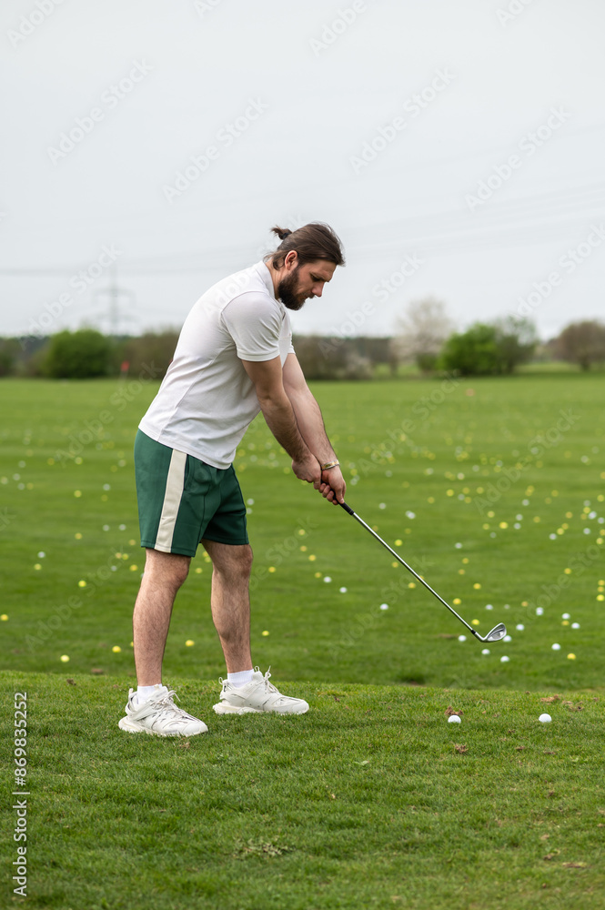 Fototapeta premium Man with golf ball on lawn for game enjoying match and competition on golfing course