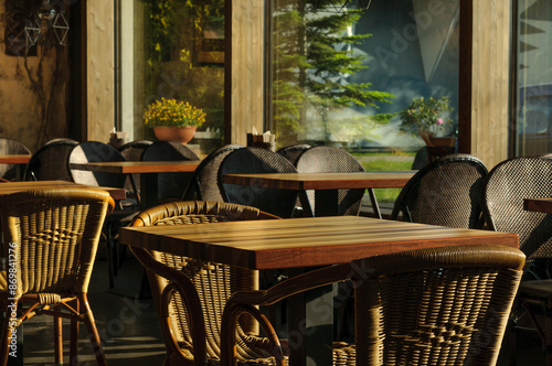 Wicker chairs and wooden tables in a cozy street cafe