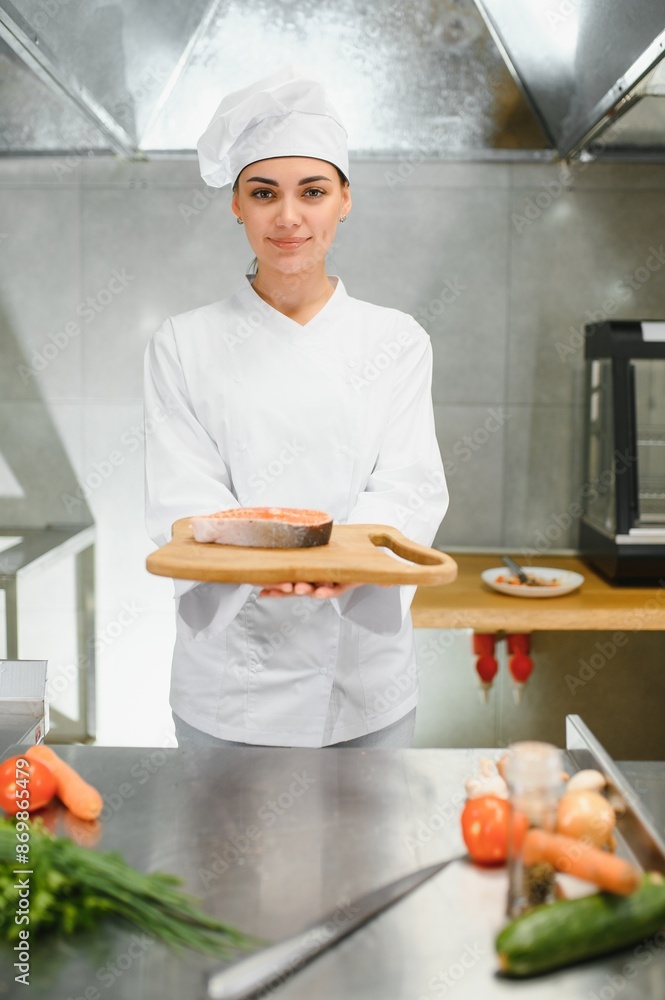 Portrait of young beautiful female chef in restaurant kitchen Portrait of young beautiful female chef in restaurant kitchen