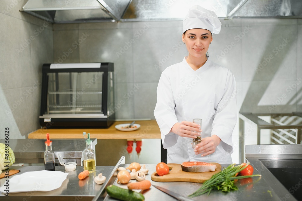 Portrait of young beautiful female chef in restaurant kitchen Portrait of young beautiful female chef in restaurant kitchen