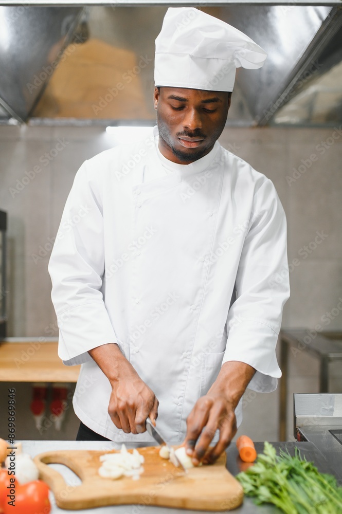 Portrait of happy African American male chef standing in restaurant kitchen Portrait of happy African American male chef standing in restaurant kitchen