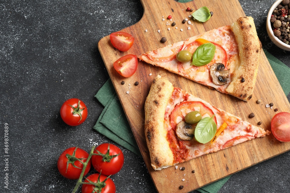 Cut delicious vegetarian pizza, spices and tomatoes on grey table, top view Cut delicious vegetarian pizza, spices and tomatoes on grey table, top view