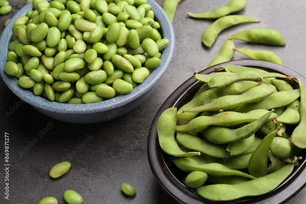 Raw green edamame soybeans and pods on grey table, closeup Raw green edamame soybeans and pods on grey table, closeup