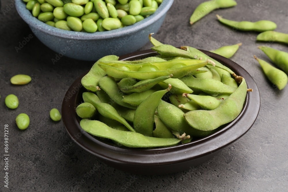 Raw green edamame soybeans and pods on grey table, closeup Raw green edamame soybeans and pods on grey table, closeup