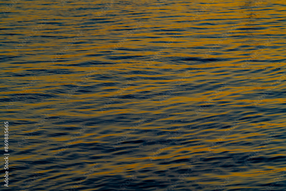 The reflection of golden colors on the surface of the water in the evening sun The reflection of golden colors on the surface of the water in the evening sun
