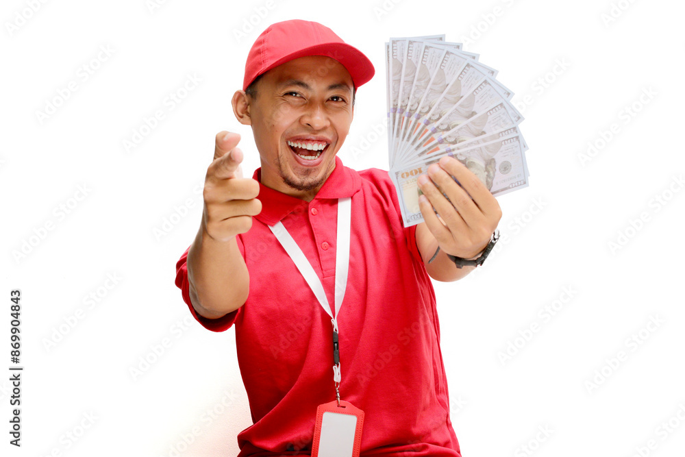 Asian delivery man or courier points towards the camera while holding money banknotes, isolated on white background. Concepts of professionalism, customer engagement, and secure monetary transactions. Asian delivery man or courier points towards the camera while holding money banknotes, isolated on white background. Concepts of professionalism, customer engagement, and secure monetary transactions.