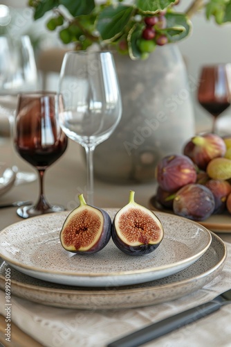 Two Halved Figs on a Speckled Plate With Wine Glasses and Fruit