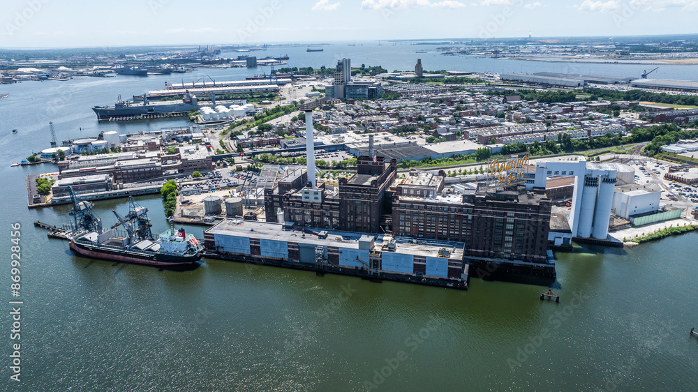 Baltimore, MD, USA, aerial city view of area around districts Tide Point and Locust Point with Domino Sugar Baltimore located at Patapsco River at Inner Harbor with a vessel moored at pier Baltimore, MD, USA, aerial city view of area around districts Tide Point and Locust Point with Domino Sugar Baltimore located at Patapsco River at Inner Harbor with a vessel moored at pier