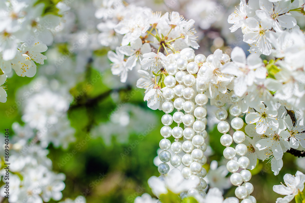 A pearl necklace hangs on the branches of a cherry blossom A pearl necklace hangs on the branches of a cherry blossom