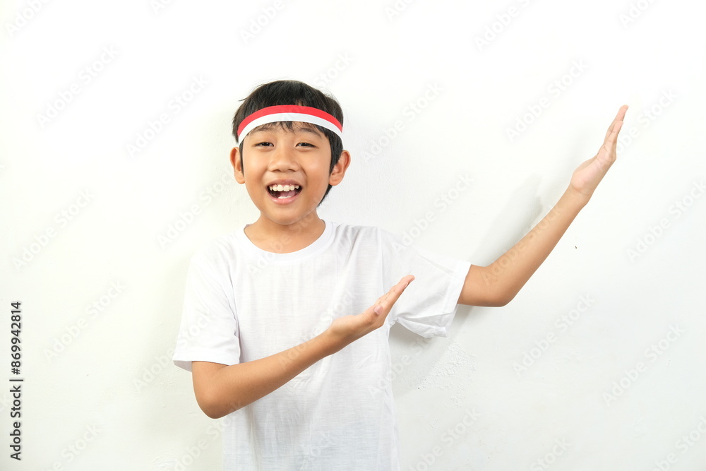 A joyful boy wearing a white shirt and an Indonesian flag headband with red and white stripes gestures enthusiastically. Perfect for themes of youth, patriotism, sports, and positive energy A joyful boy wearing a white shirt and an Indonesian flag headband with red and white stripes gestures enthusiastically. Perfect for themes of youth, patriotism, sports, and positive energy