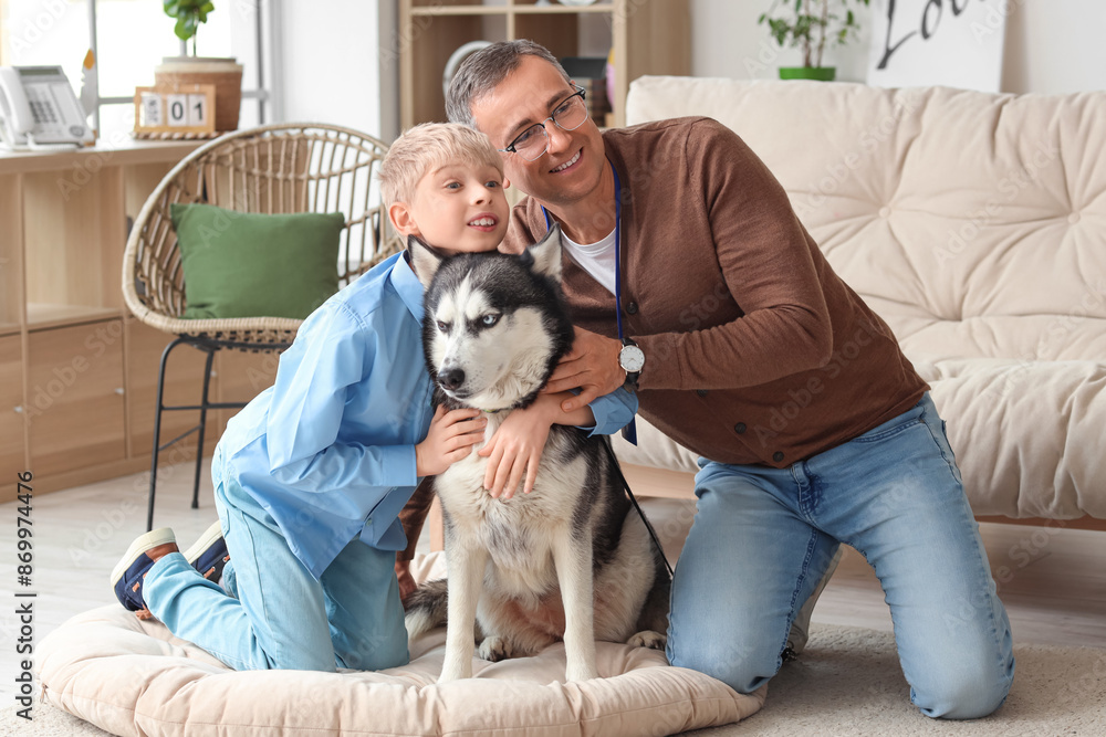 Mature doctor with his little son and cute Husky dog at home
