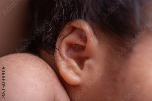 Little newborn human baby ear listening