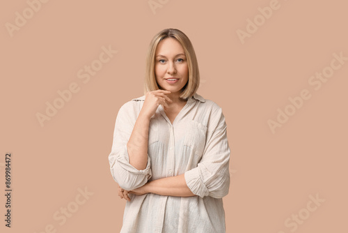 Beautiful young woman with bob hairstyle on brown background © Pixel-Shot