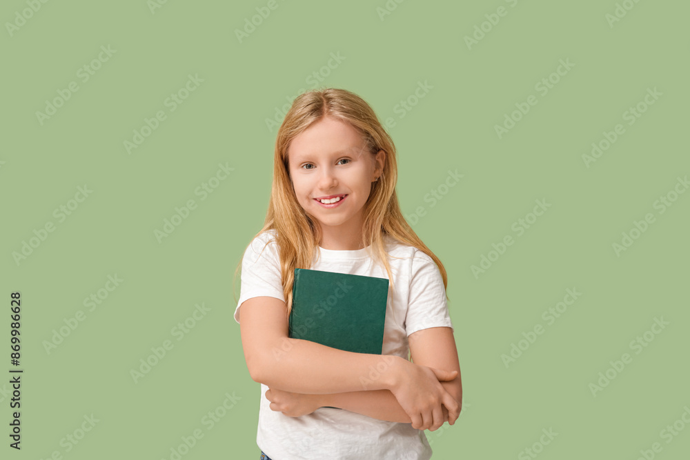 Cute little girl with book on green background