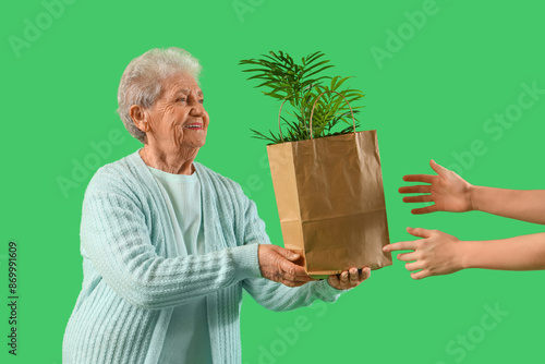 Senior florist giving shopp...
