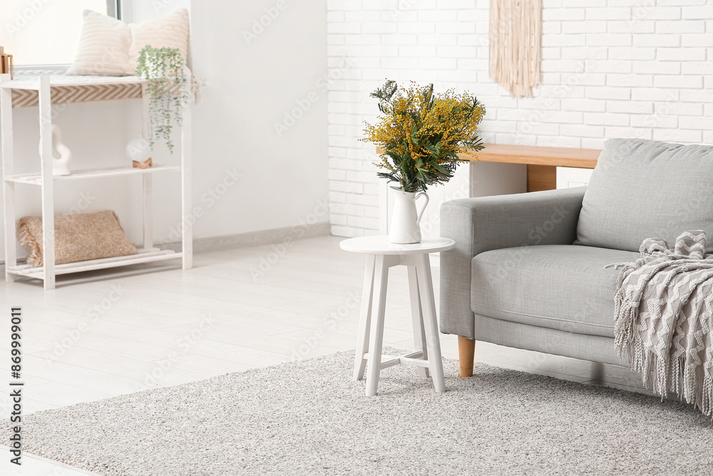 © Pixel-Shot - Vase with beautiful mimosa flowers on table in light living room