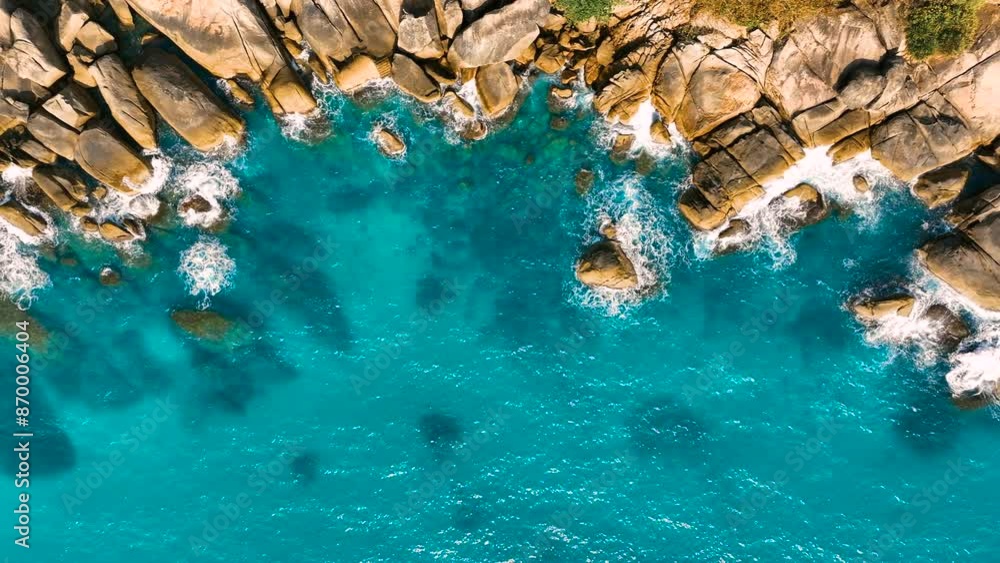 Waves foam and rock. Aerial view of crashing waves on rocky shore. Economy is tourism. Beautiful clear blue ocean sea. Rocky cliff. 