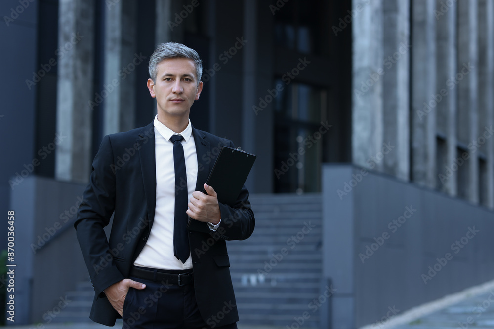 Fototapeta premium International relations. Diplomat with clipboard in suit outdoors, space for text
