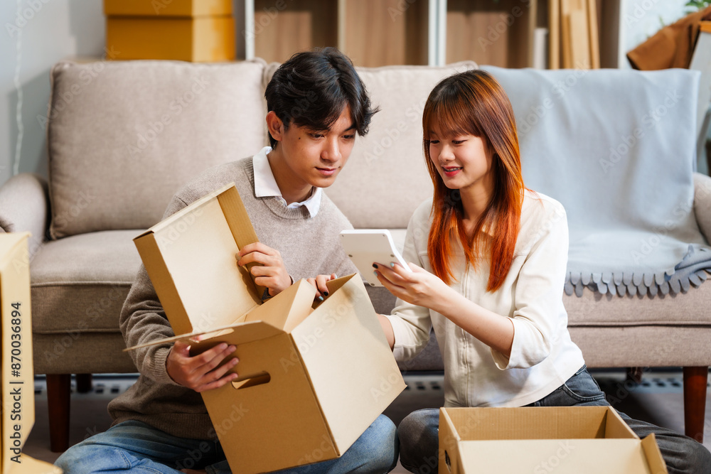 Young women, men, and Asian people prepare for moving into a new home. From unpacking supplies to updating documents, follow a comprehensive checklist in the living room with a big cardboard box. Young women, men, and Asian people prepare for moving into a new home. From unpacking supplies to updating documents, follow a comprehensive checklist in the living room with a big cardboard box.