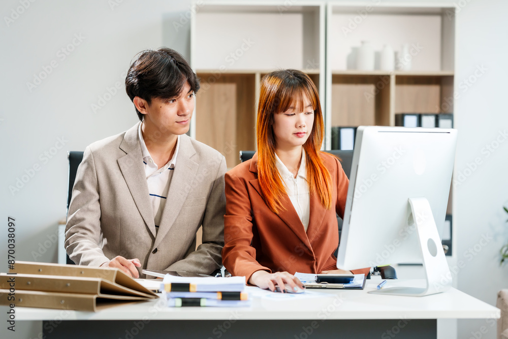 Young Asian businesswoman and businessman work together at desks, focusing on policy and planning analysis and various financial roles, emphasizing teamwork and professional collaboration. Young Asian businesswoman and businessman work together at desks, focusing on policy and planning analysis and various financial roles, emphasizing teamwork and professional collaboration.