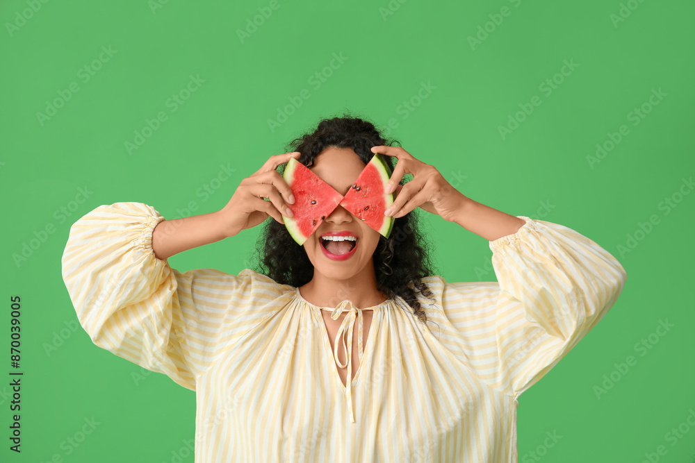 Funny young African-American woman with fresh watermelon on green background Funny young African-American woman with fresh watermelon on green background