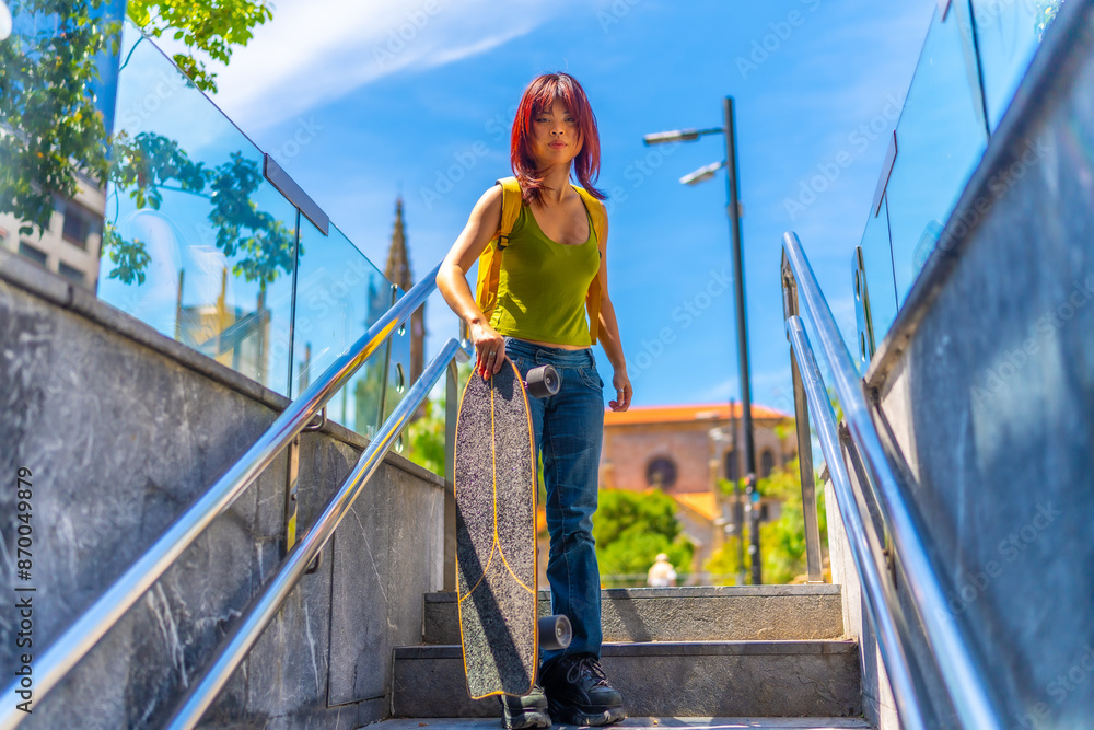 Urban portrait of a chinese young woman holding skateboard outdoors Urban portrait of a chinese young woman holding skateboard outdoors