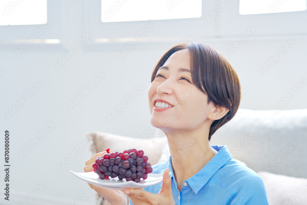自宅でぶどうを食べる女性 自宅でぶどうを食べる女性