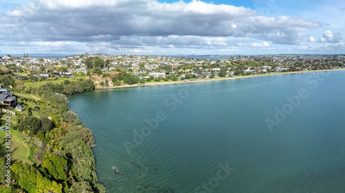 Ocean coastline and residential housing in Tindalls Beach, Whangaparāoa, Auckland, New Zealand.