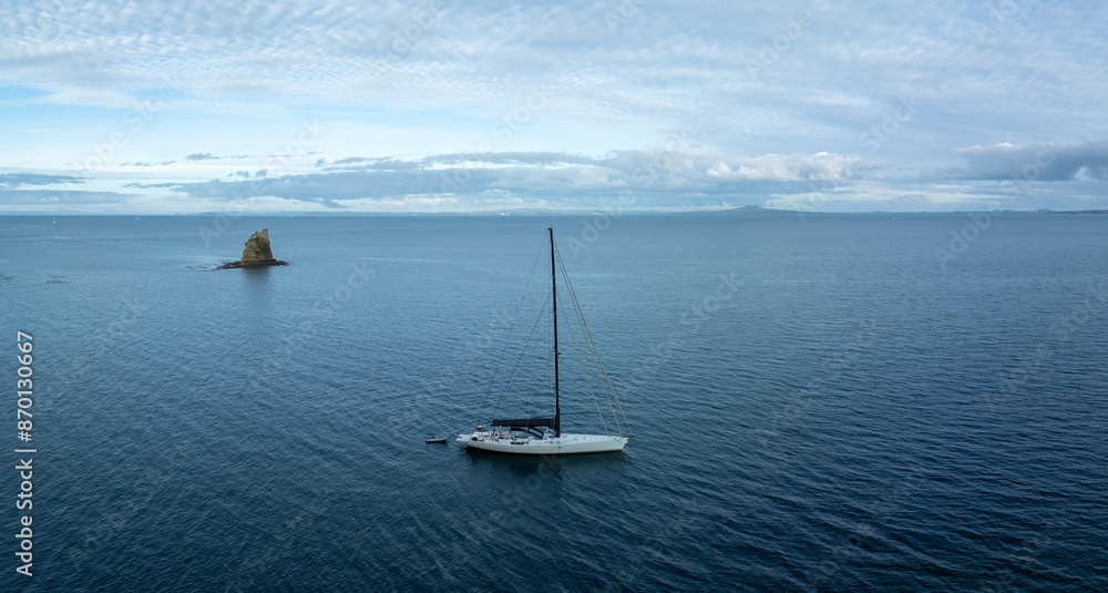 Fototapeta premium Sailboat docked in the Hauraki Gulf. Matakatia with an island in the background, Whangaparoa, Auckland, New Zealand.