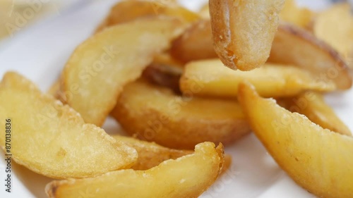 CloseUp of Tasty Fried Potato Wedges on a Plate, Perfect for Snacking or as a Side Dish photo