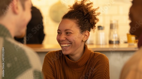 Smiling woman enjoying a friendly conversation with friends in a cozy cafe setting, showcasing warmth and happiness. photo