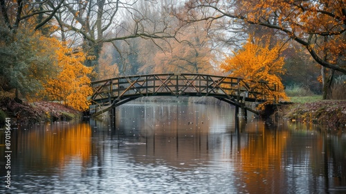 A peaceful river view with a wooden bridge and autumn leaves reflected in the water.