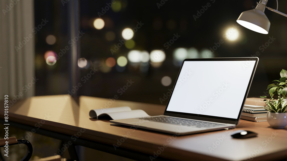 A laptop computer mockup on wooden table against the window with city nightlight view. A laptop computer mockup on wooden table against the window with city nightlight view.