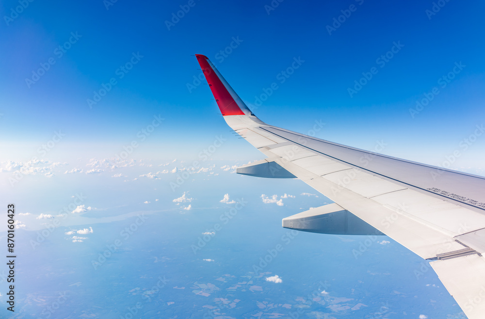 View from the airplane window at a beautiful cloudy sky and the airplane wing View from the airplane window at a beautiful cloudy sky and the airplane wing