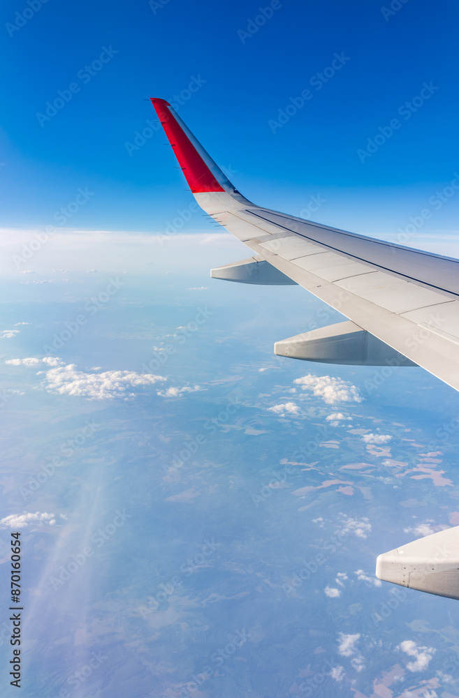 View from the airplane window at a beautiful cloudy sky and the airplane wing View from the airplane window at a beautiful cloudy sky and the airplane wing