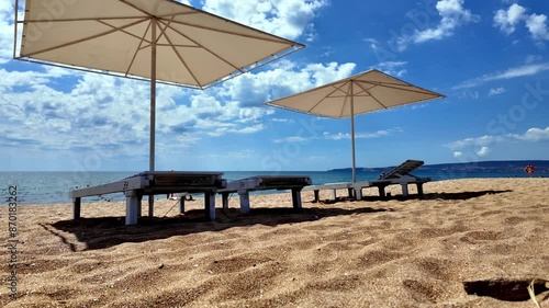 A sunny day on a Crimean beach with white umbrellas and comfortable loungers. photo