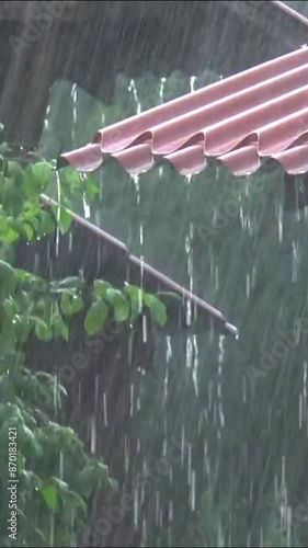 Streams of rain run off the roof.  Water runoff during rain. vertical video