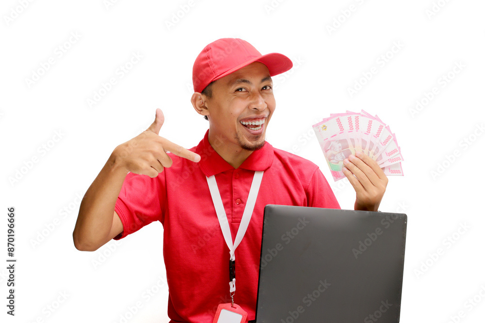 Asian delivery man, holding money while using a laptop against a white background. Concept of professionalism, e-commerce management, financial transactions, delivery services, and business efficiency Asian delivery man, holding money while using a laptop against a white background. Concept of professionalism, e-commerce management, financial transactions, delivery services, and business efficiency