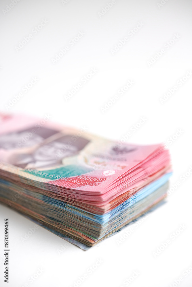 A stack of various Indonesian rupiah banknotes on a white background A stack of various Indonesian rupiah banknotes on a white background