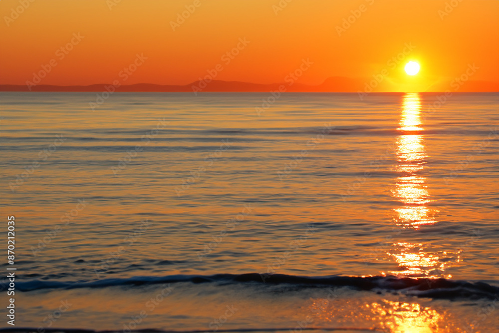 Obraz premium Sunset over the sea with horizon. Ocean landscape beach concept. Sun at sunset in the sky and sea. Sun at sunset on the horizon with sea and lifestyle clouds.