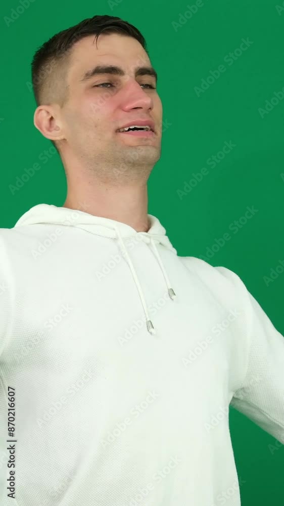 Man exhales in relief. emotions of a handsome man guy on green background chromakey close-up dark hair young man Man exhales in relief. emotions of a handsome man guy on green background chromakey close-up dark hair young man