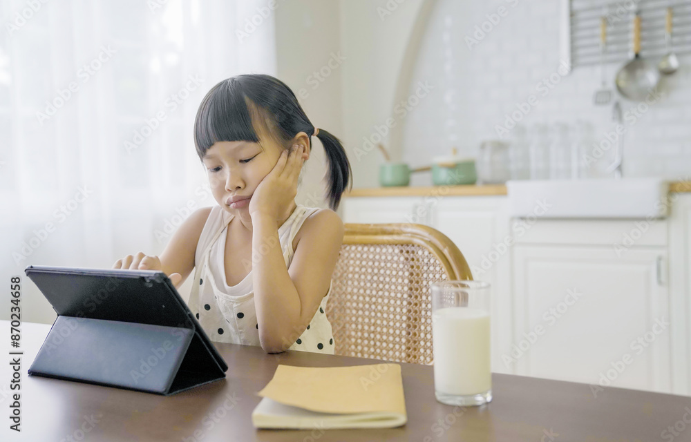 Portrait of Asian girl using computer to learn online live lessons in elementary school. Student girl bored study in primary Children with gadgets at home. Education knowledge, technology internet Portrait of Asian girl using computer to learn online live lessons in elementary school. Student girl bored study in primary Children with gadgets at home. Education knowledge, technology internet