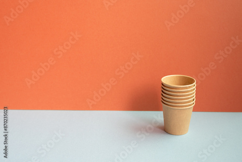 Obraz na płótnie Disposable kraft paper cups on gray table. red wall background w salonie