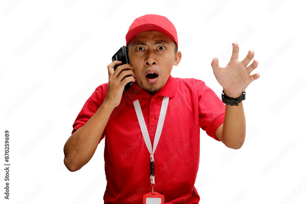 Shocked Asian delivery man or courier receiving unexpected news about a delivery during a phone call. Isolated on a white background Shocked Asian delivery man or courier receiving unexpected news about a delivery during a phone call. Isolated on a white background